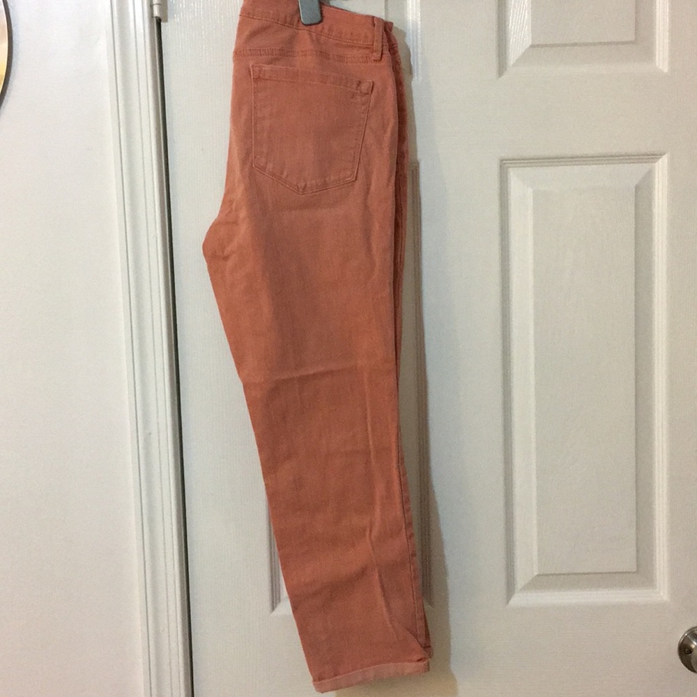 Salmon/peach colored jeans.